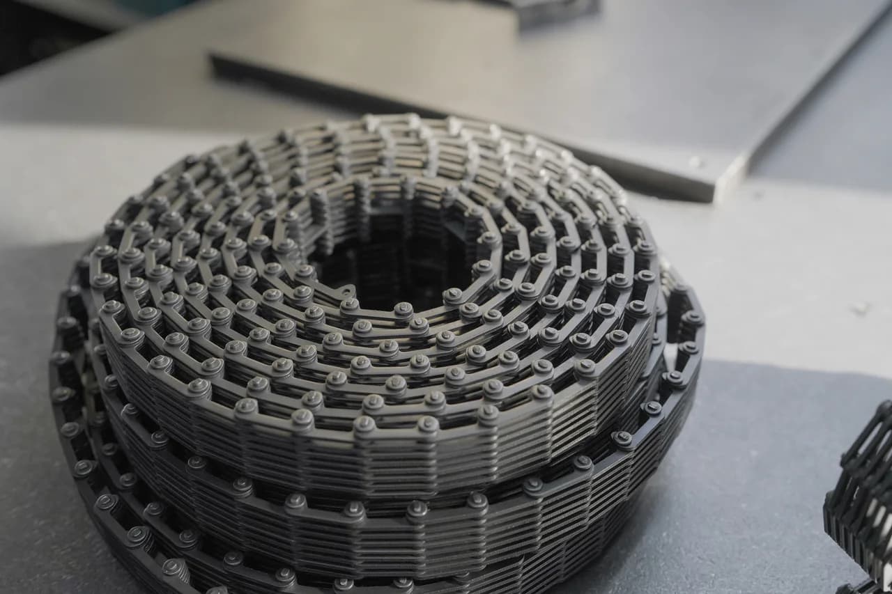 Large conveying-chain assembly coiled on a workshop table