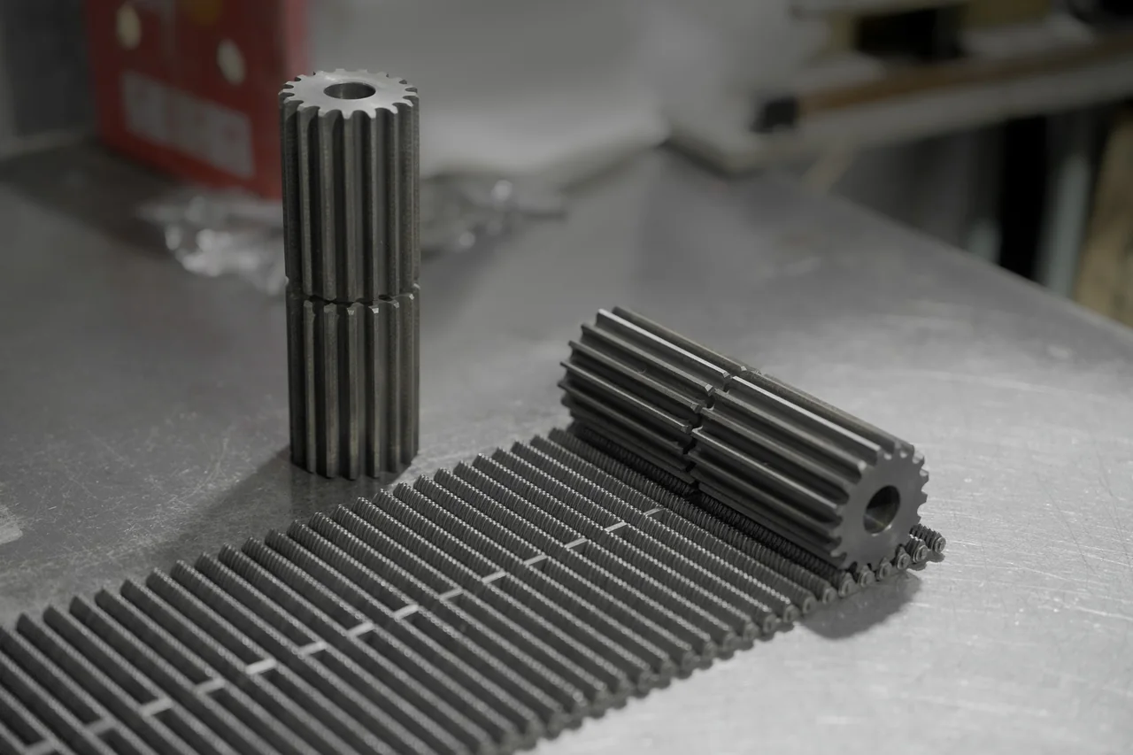 Conveying-chain sections and sprocket samples on a workshop surface
