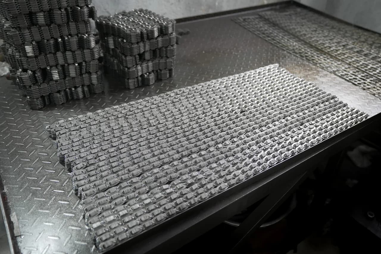 Multiple P.I.V. chain sections and coils arranged on a workbench