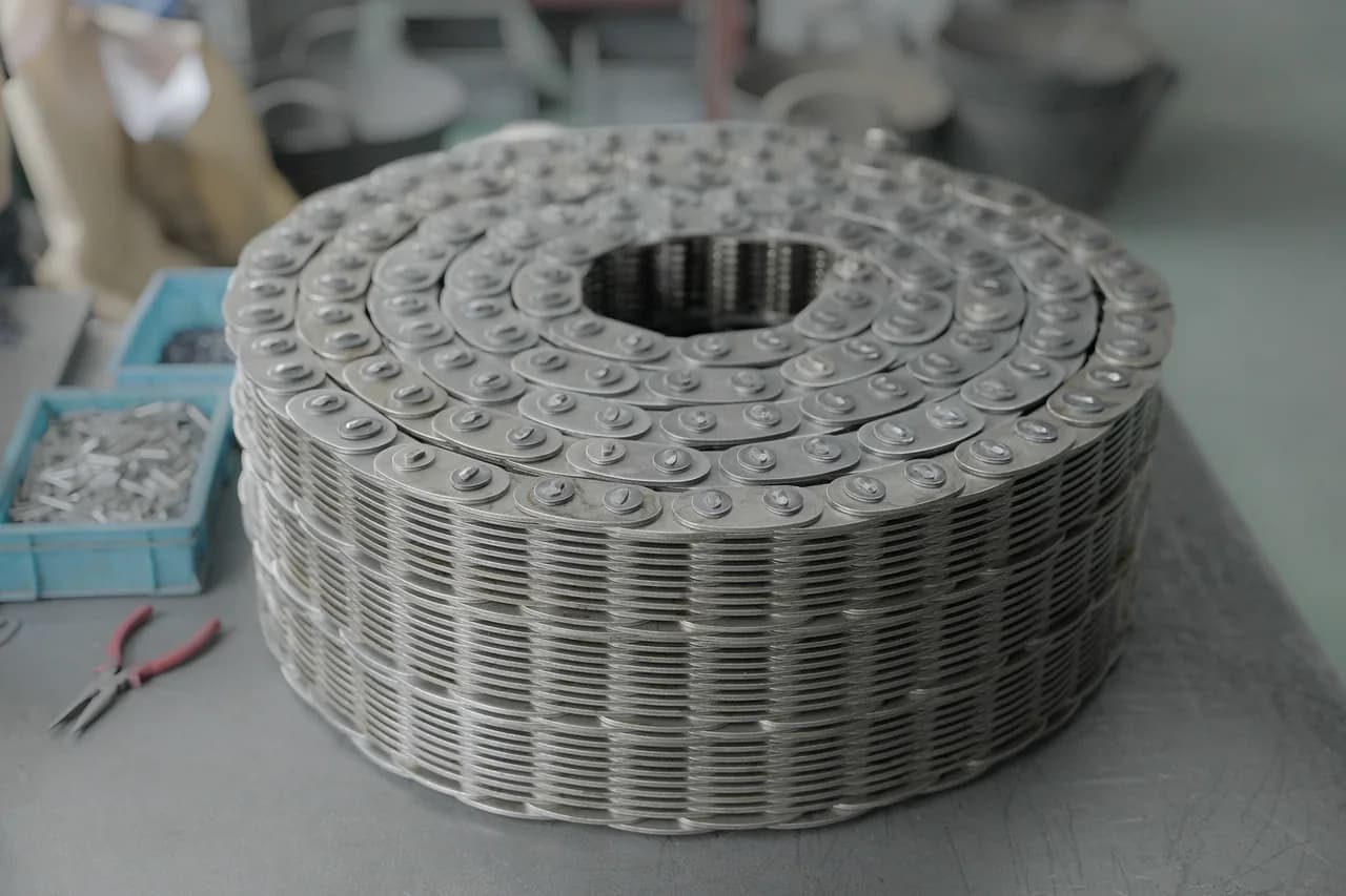 Wide finished silent chain coiled on a workshop table
