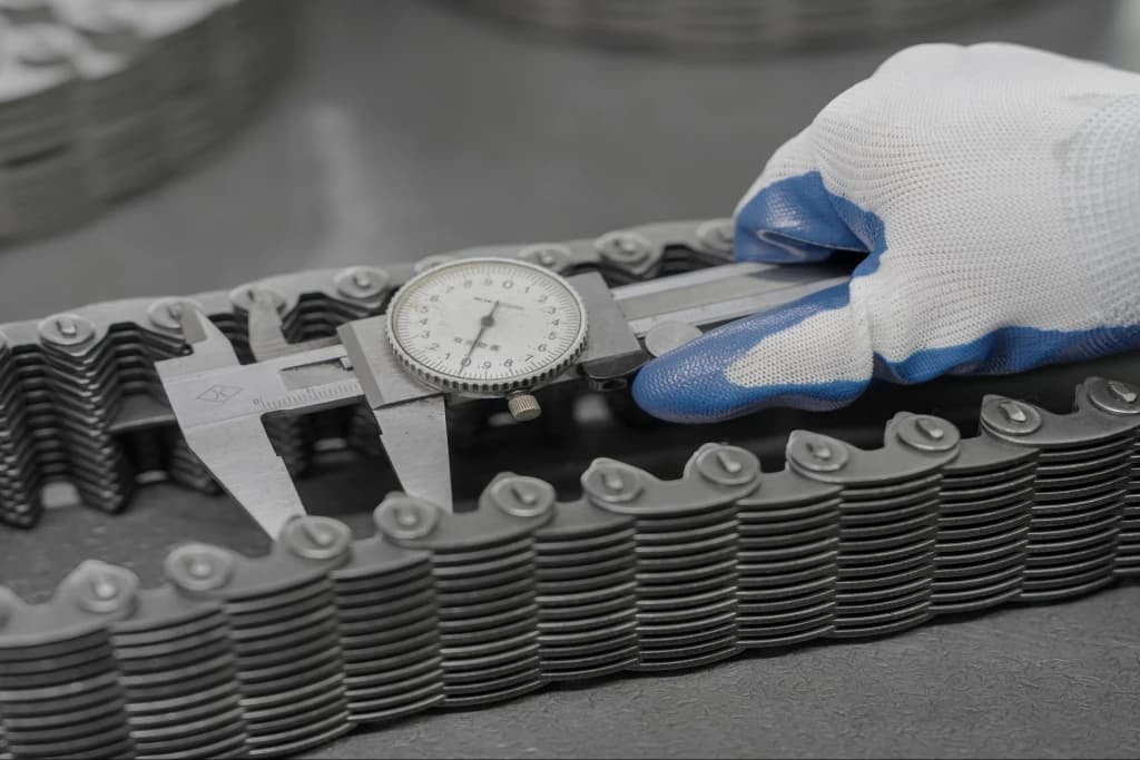 Dial calliper positioned across a chain during inspection