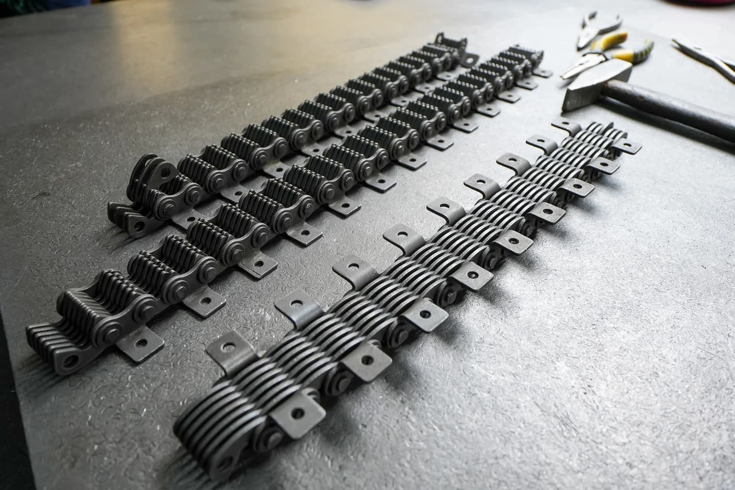 Several non-standard chain samples arranged on a workshop table