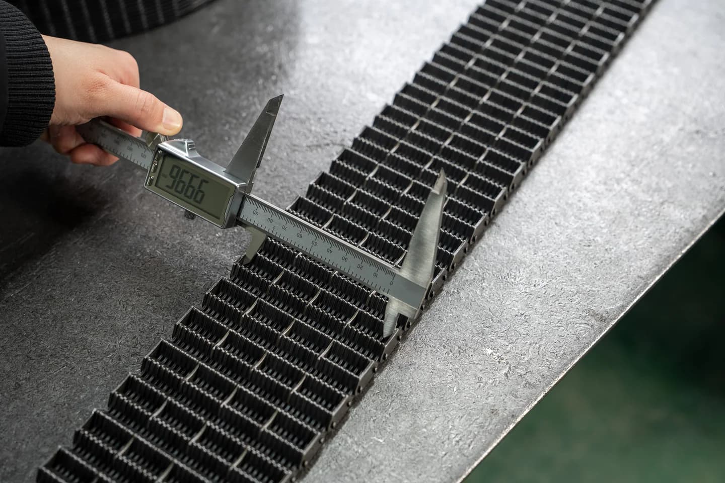 Digital calliper measuring the width of a physical chain sample