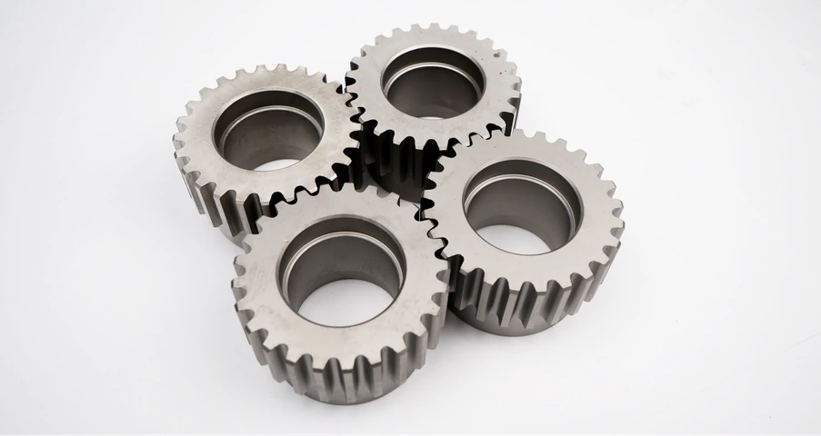 Four machined sprockets arranged on a light surface
